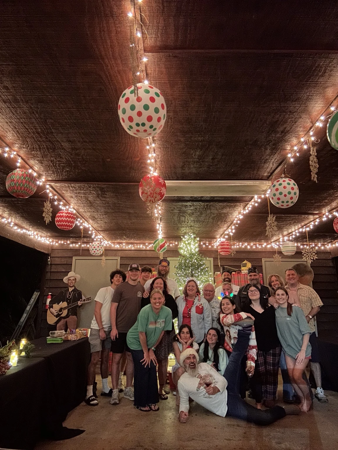 A festive group celebration with a Christmas tree and holiday decorations